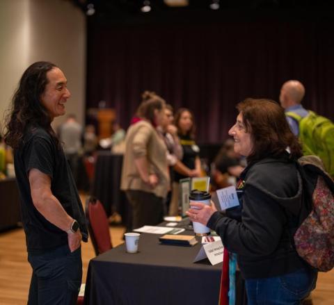 two UO employees talking and smiling