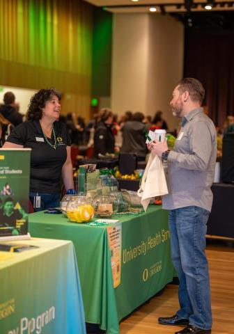 two employees talking over a table at the resource fair