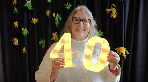 woman holds illuminated 4 and 0